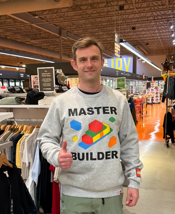 Kyle in a LEGO Master Builder sweater, giving a thumbs up